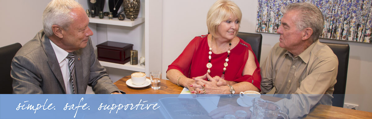 A funeral director and couple having a warm consultation over coffee at a table